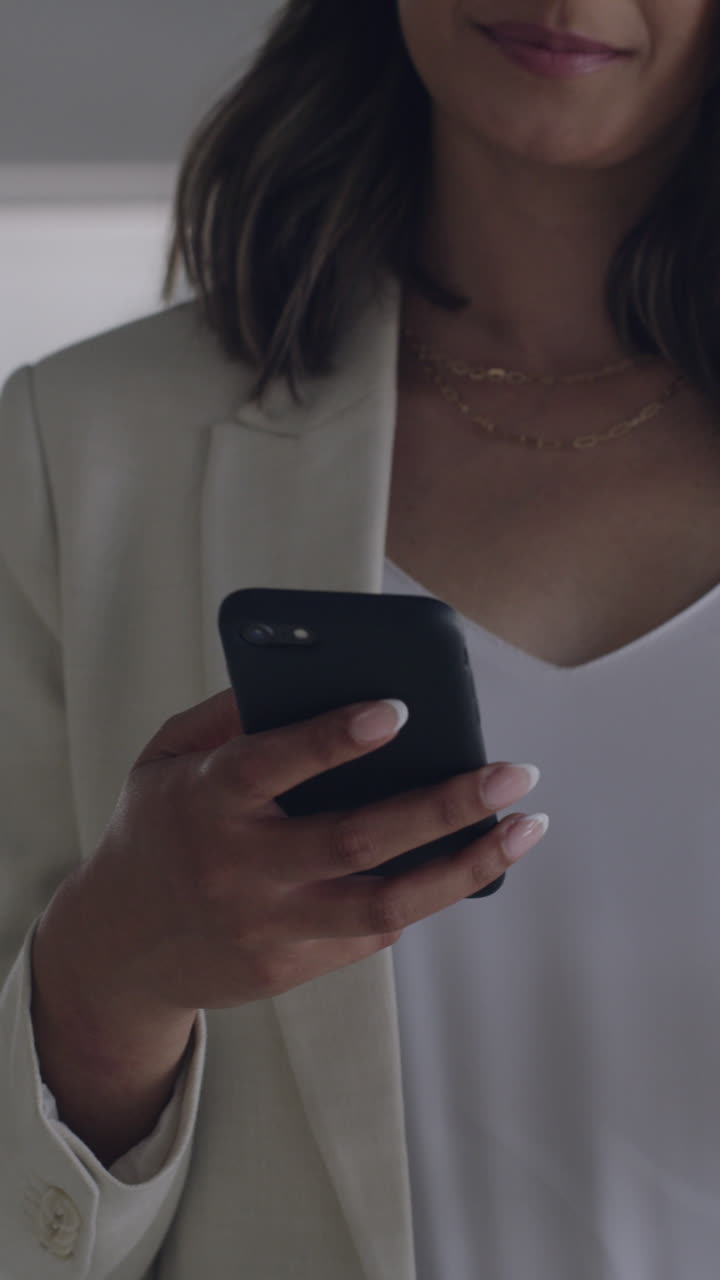 Primo piano di donna che usa lo smartphone e tiene in mano una tazza di caffè