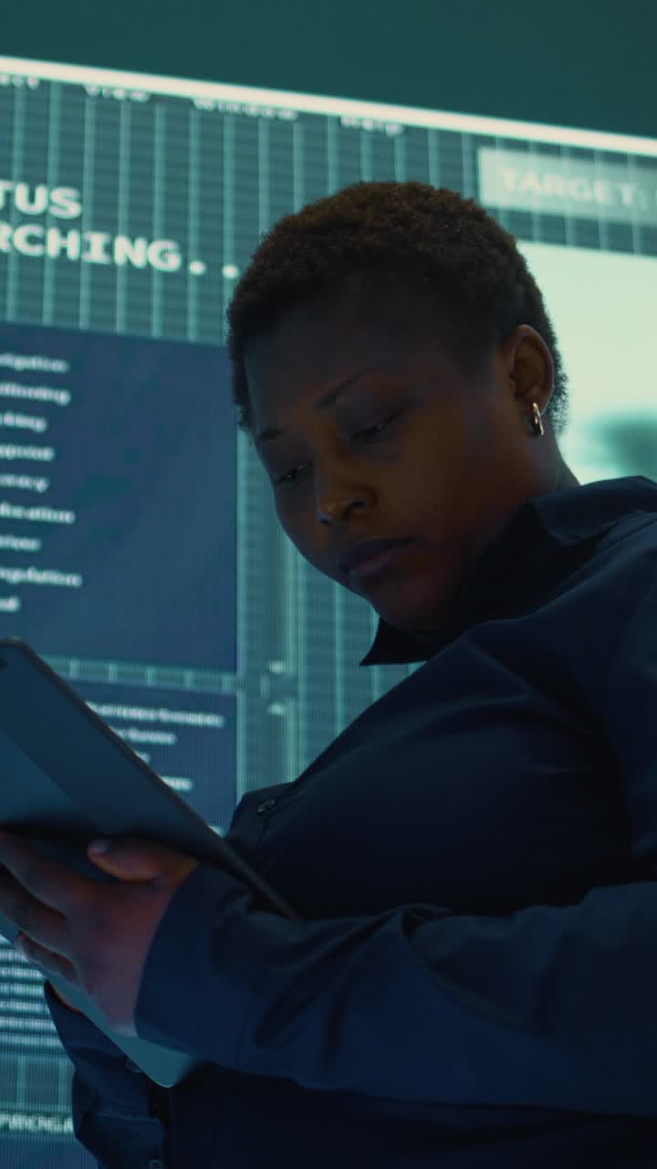 African American Woman Using Tablet in High-Tech Control Room