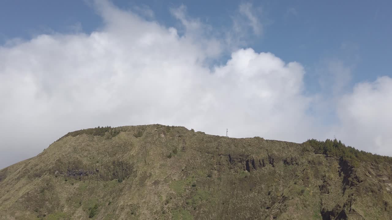 Pan shot from girl walking along path towards Miradouro da Boca do Inferno, Sao Miguel, Portugal