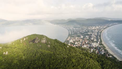 drone-panning-around-a-cloudy-peak-of-a-tropical-forest-mountain-in-a-summer-day