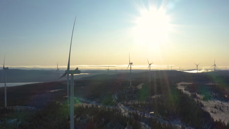 Windmills-Towering-Over-The-Countryside-Full-Of-Trees-With-The-Sunlight-Brightly-Shining-In-Osen,-Norway---Aerial-Shot