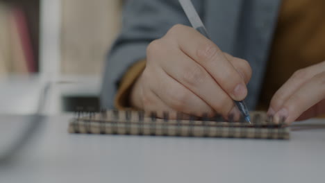 persona que escribe en un cuaderno