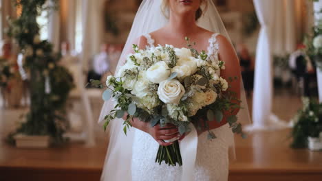 bride holding a white floral bouquet on her wedding day