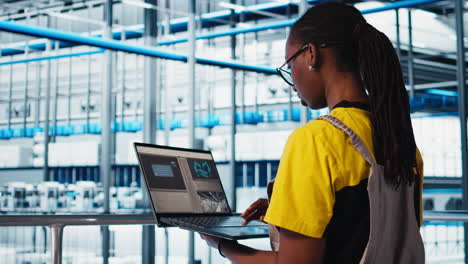 experto en fábricas fotovoltaicas inteligentes que mira las métricas en el software de la computadora portátil