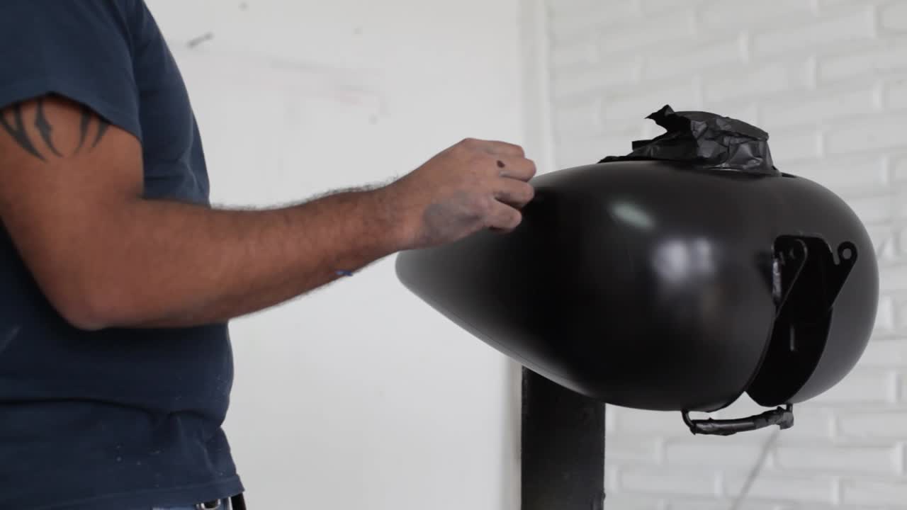 기계가 차고에서 모터사이클을 위해 맞춤형 페인팅을 하고 있습니다.