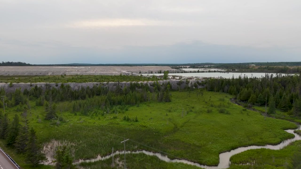 Un drone révèle des canaux sinueux de zones humides et des herbes de marais éclatantes s'étendant le long d'une route rurale dans la péninsule supérieure du Michigan.
