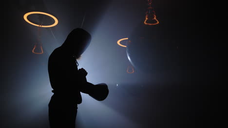silhouette of a boxer in a dark gym
