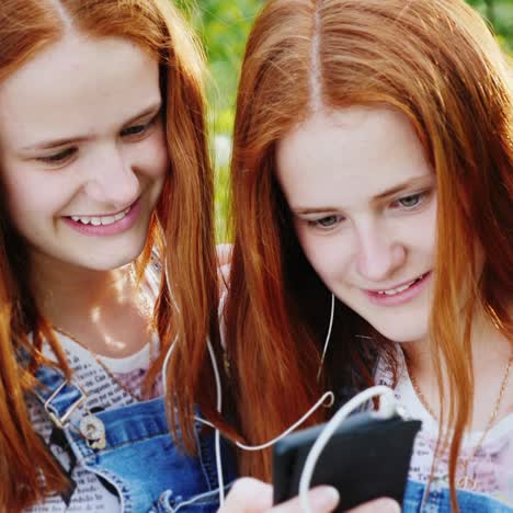 two cool twins girls are listening to music outdoors 1