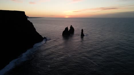 reynisfjara rocks and cliffs on iceland coastline at sunset, aerial landscape