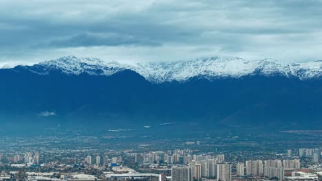 snowy andes mountain range with urban city view under cloudy sky in colombia