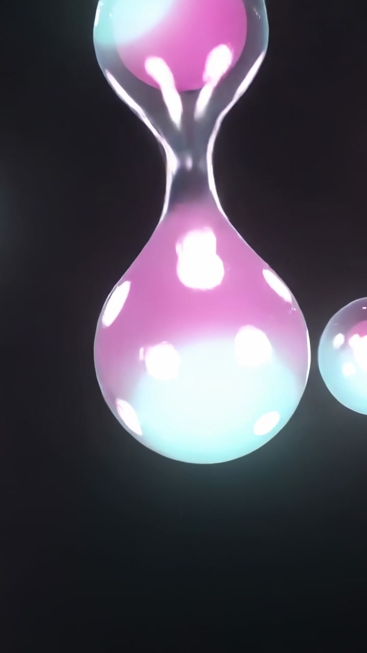 Vertical video: Center bubble growing, pulling group into pinch from tension on black, magenta cyan