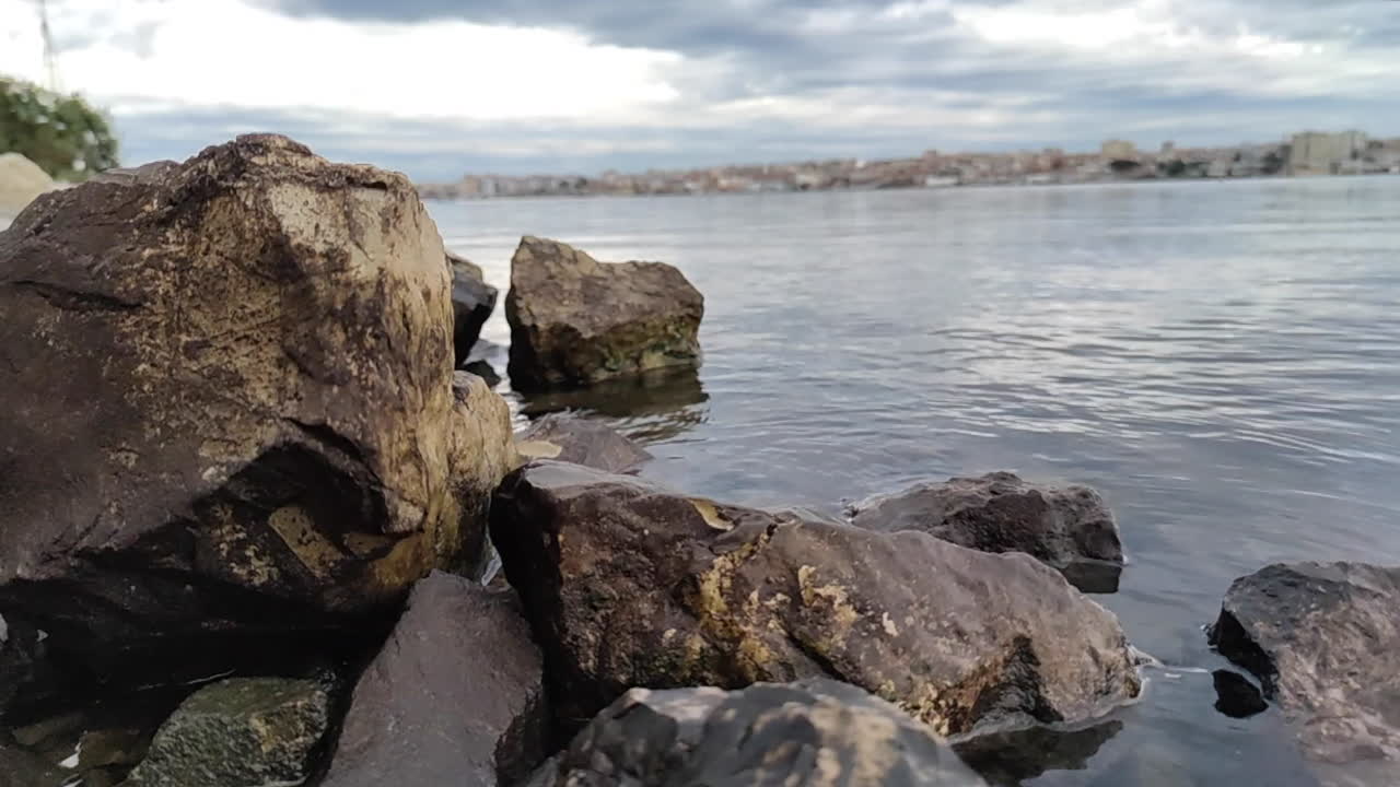 grandes rocas a través de aguas tranquilas bajo un cielo nublado en el río southbank de portugal