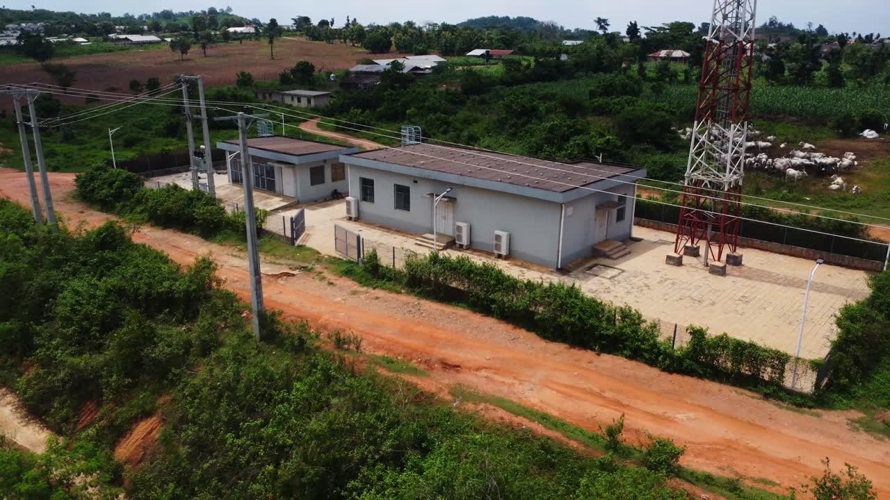 Drone flyver tilbage fra en transformatorstation og afslører togskinner, der løber gennem det smukke og landlige landskab i Nigeria, Afrika