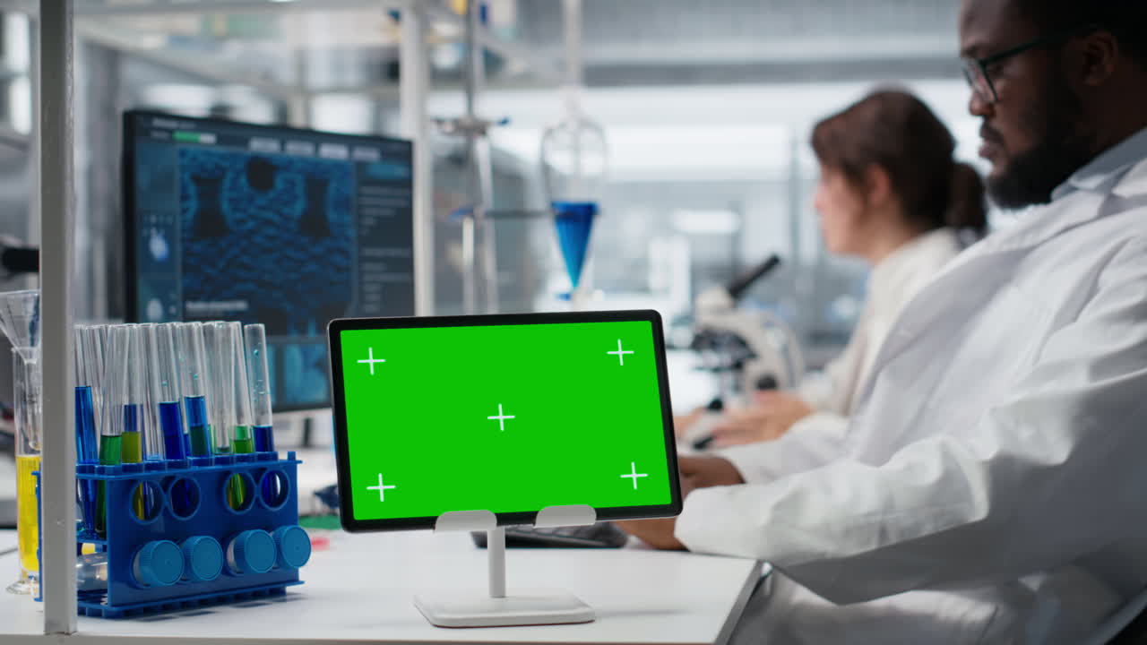 Bioinformatics Scientist Working On Green Screen Tablet In Lab