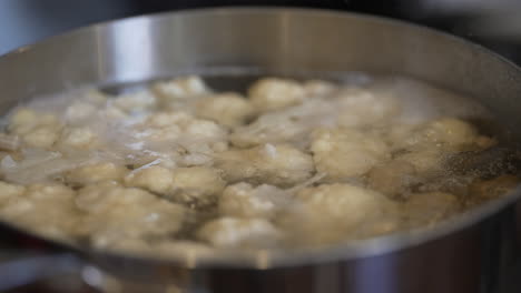 a hot pot of boiling cauliflower - bubbling steamy water isolated in slow motion