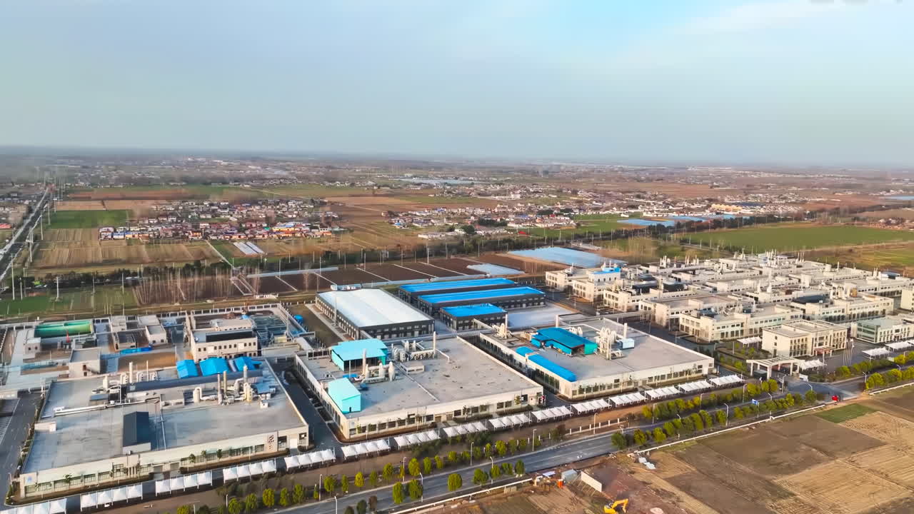 Large modern factory for the production of electronic equipment and batteries, an industrial city with many buildings. Contemporary factory with car parking. Industrial complex among green fields.