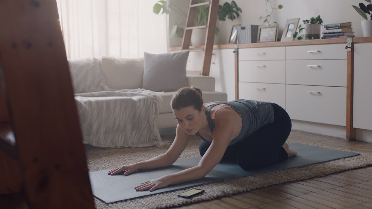 mujer de yoga saludable haciendo ejercicio en casa practicando la pose de los niños en la sala de estar disfrutando del ejercicio físico matutino