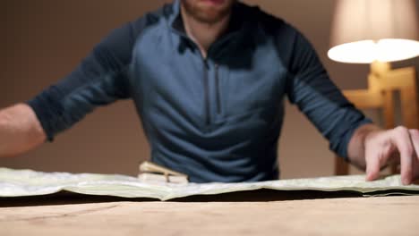unrecognizable man opens map on table. slow motion