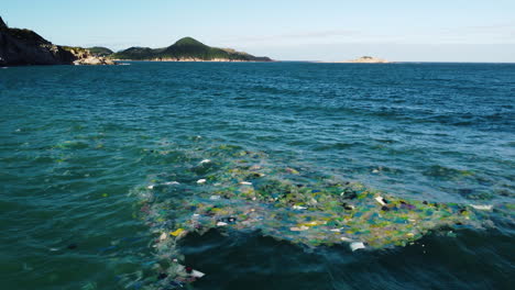 ocean water covered in plastics and rubbish near vietnam coast, slow motion shot