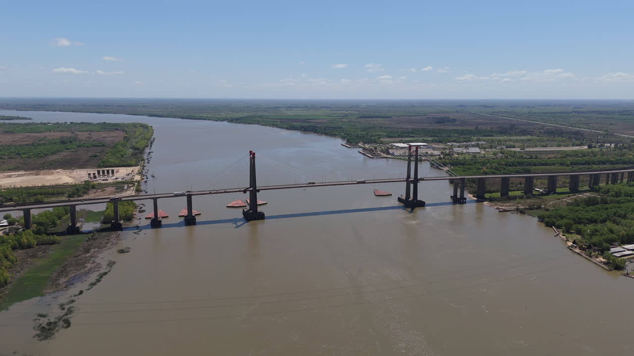Drone view of Justo Jose de urquiza bridge above the wide Parana Guazu river, a vast waterway, Buenos Aires Argentina. Pan to the left
