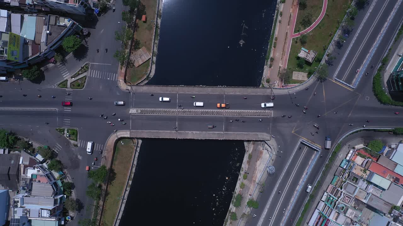 베트남 호치민시의 교통 교량과 고가도로, 운하, 옥상, 도로 교통을 특징으로 하는 화창한 날 하향식 공중 크레인 샷