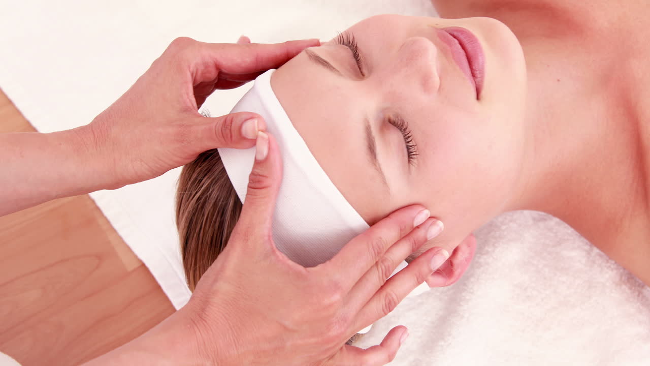 마사지사 가 고객 의 머리 를 마사지 하고 있다