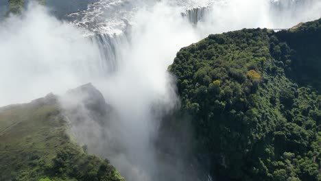 aerial drone view of victoria falls and its rainbows, in between zambia and zimbabwe