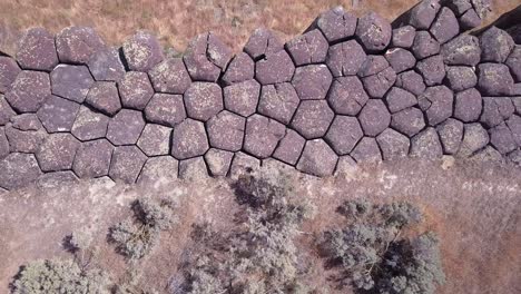 aerial flies over exposed basalt column tops forming scablands cliff