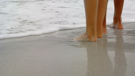 Unterer-Teil-Eines-Paares,-Das-Barfuß-Am-Strand-Steht-4K