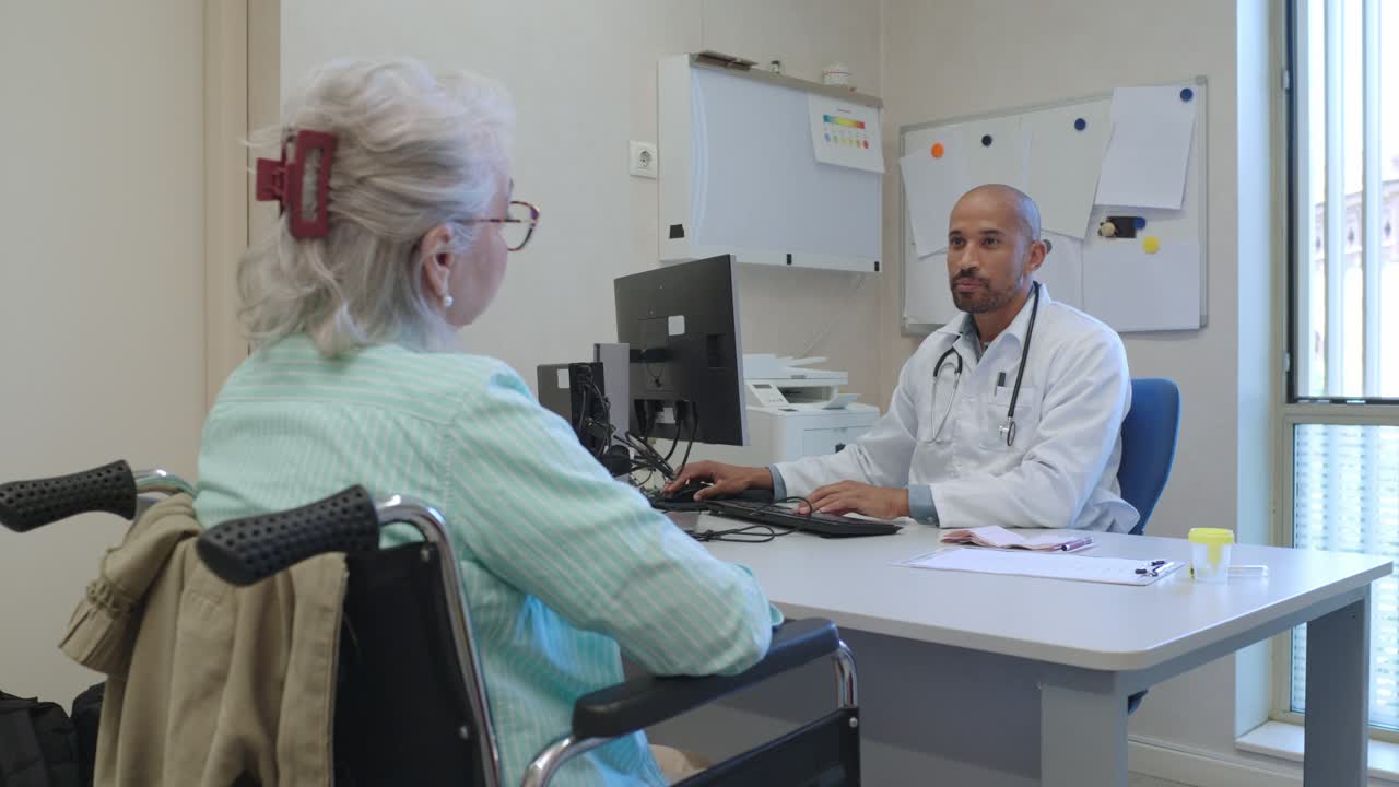 Doctor consulting with senior patient in wheelchair