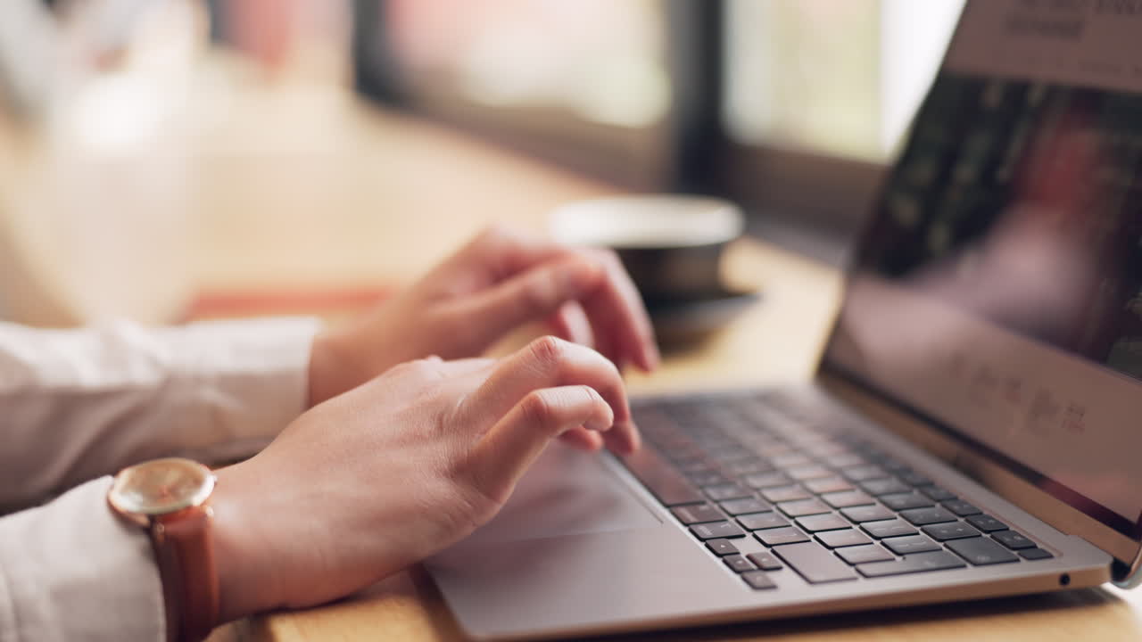 portátil, manos y pergamino en el escritorio de la oficina