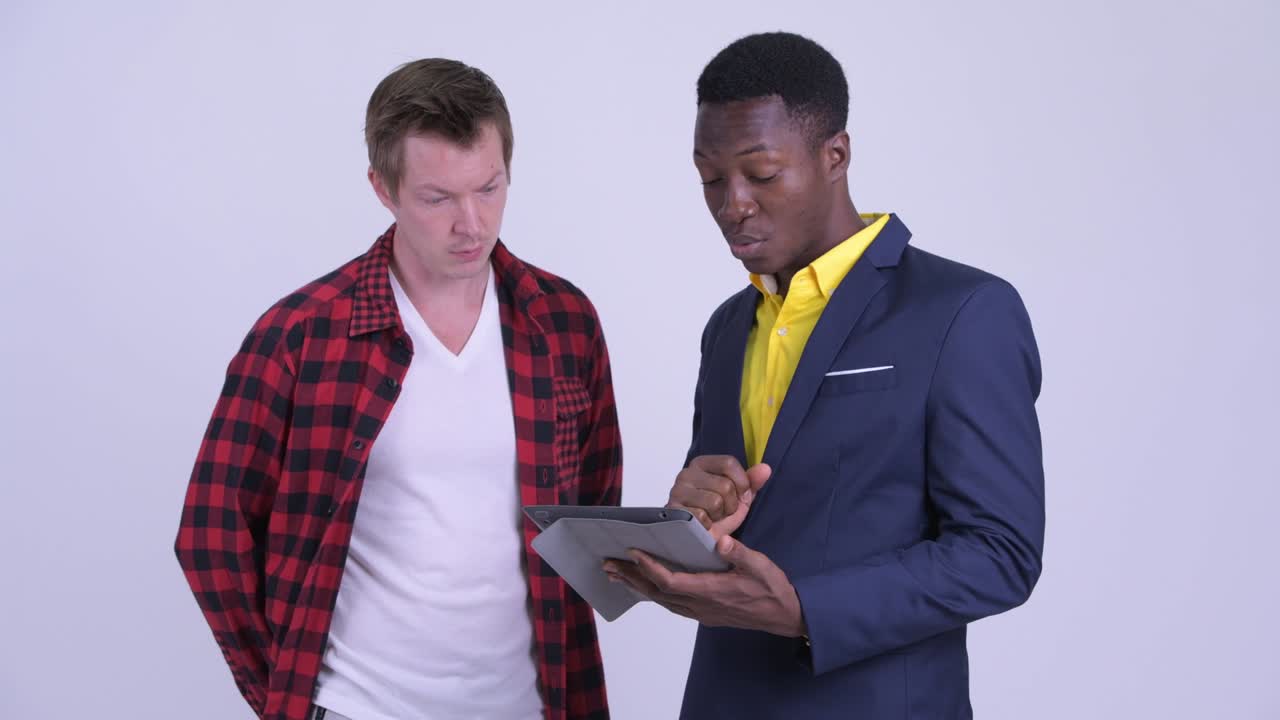 jóvenes empresarios multiétnicos hablando y usando tableta digital juntos