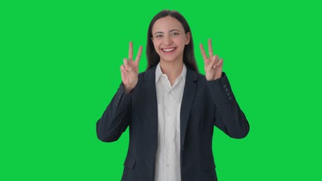 Happy-Indian-female-manager-showing-victory-sign-Green-screen