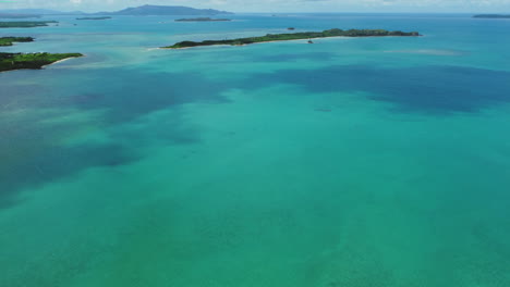 slow aerial tilt up over pristine waters, islands near boat pass, new caledonia