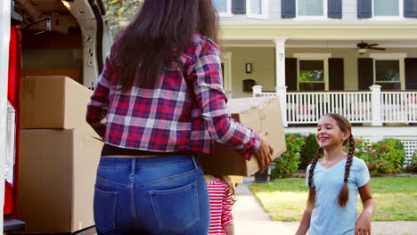 niños ayudando a descargar cajas de la furgoneta en la familia que se mueve en el día