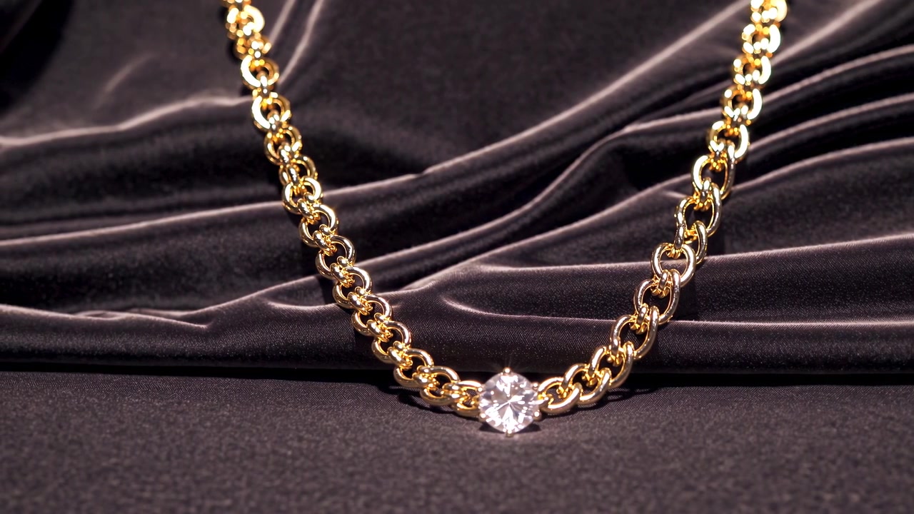 Collana di lusso a catena d'oro con diamante scintillante su velluto scuro.