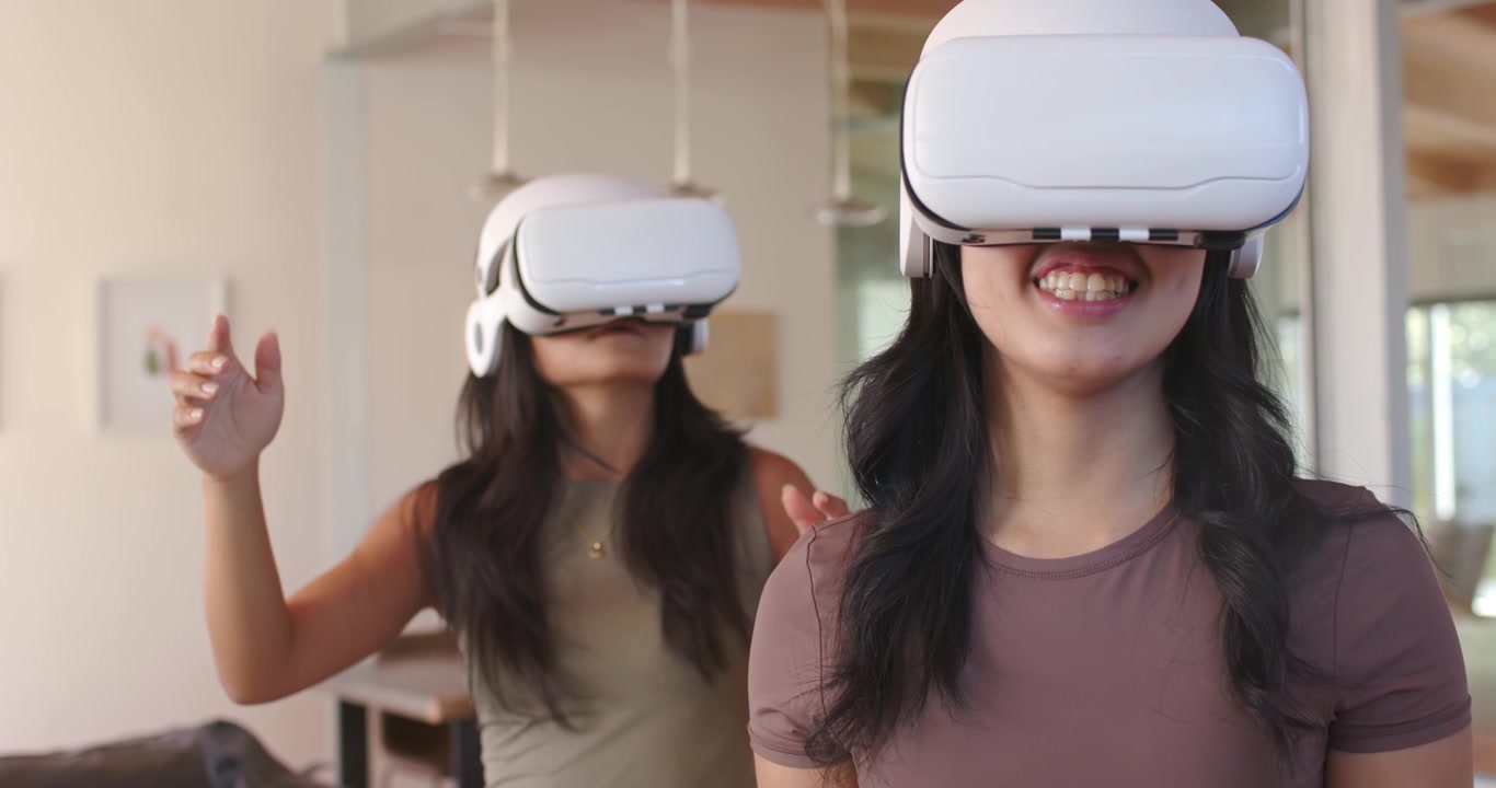 Donne di diverse etnie che indossano visori VR, gesticolando verso una scena VR, smartwatch, uomo che sorride sul divano a casa.
