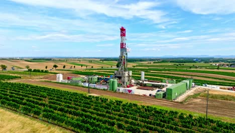 oil drilling rig and gas station industry in the countryside of austria - aerial drone shot