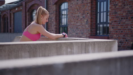 eine junge schöne fitnessfrau ruht nach einem outdoor-workout in der stadt aus