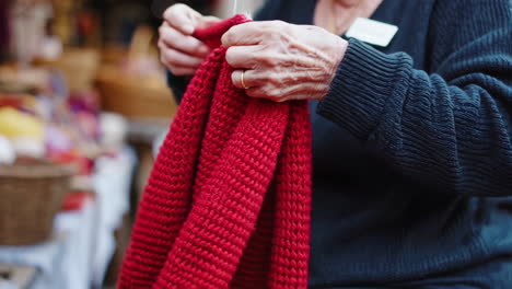 senior women at a market selling handmade knitted goods