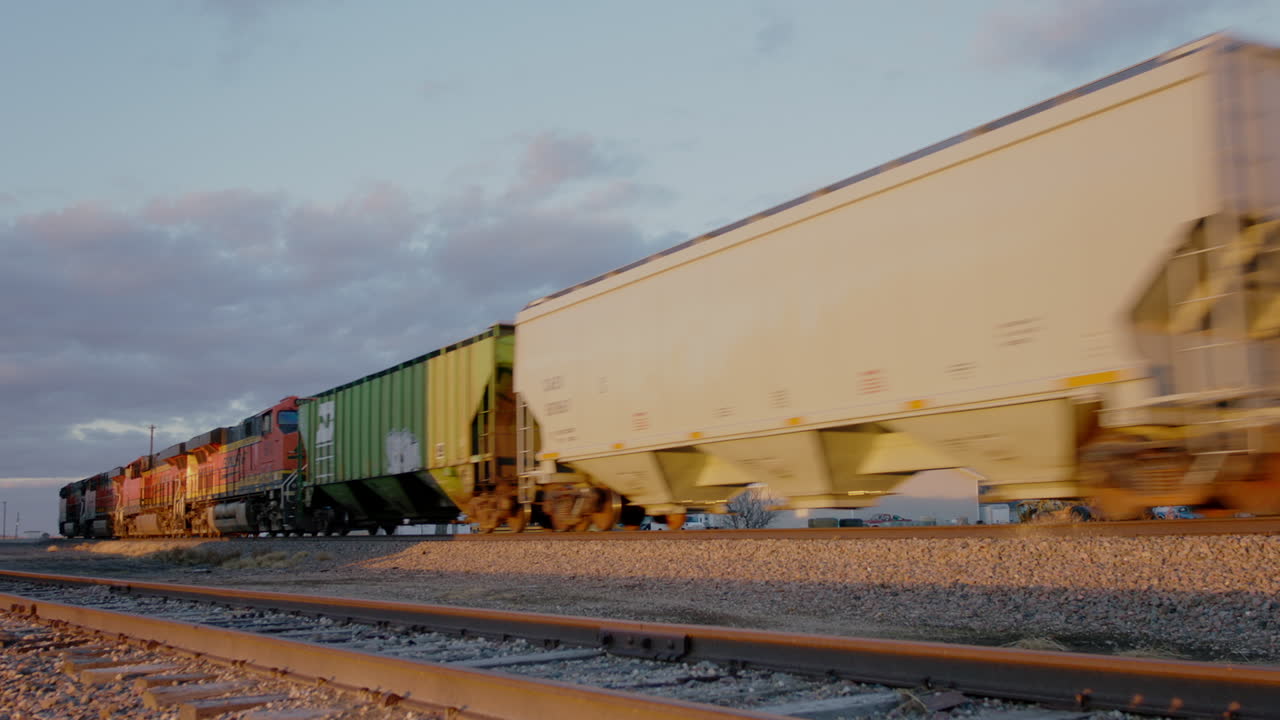 tren de carga que pasa por las tierras de cultivo estadounidenses al atardecer
