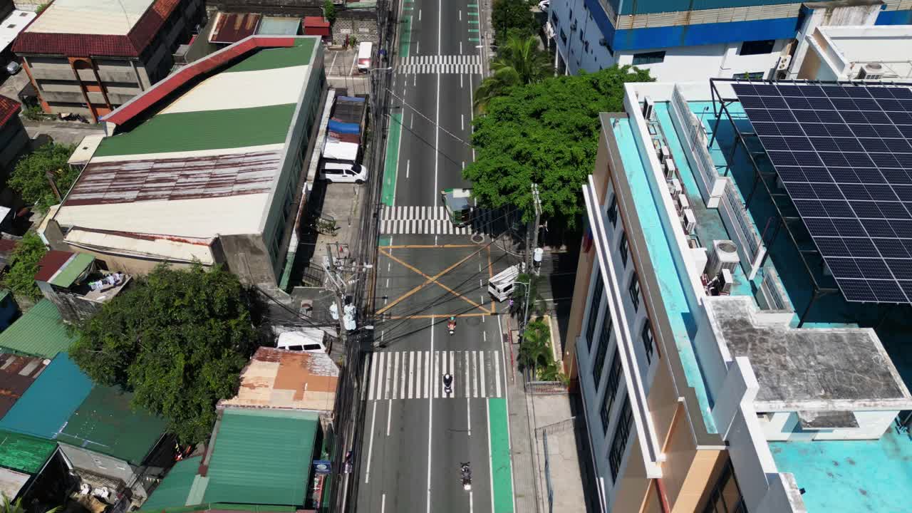 Flyover drone shot of bustling streets along Bonny Serrano Avenue, San Juan City, Philippines during daytime - aerial hyperlapse