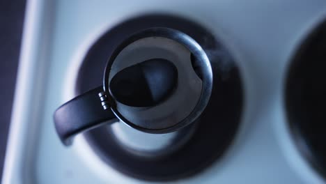 half top shot of an espresso coffe machine standing on a stove and cooking