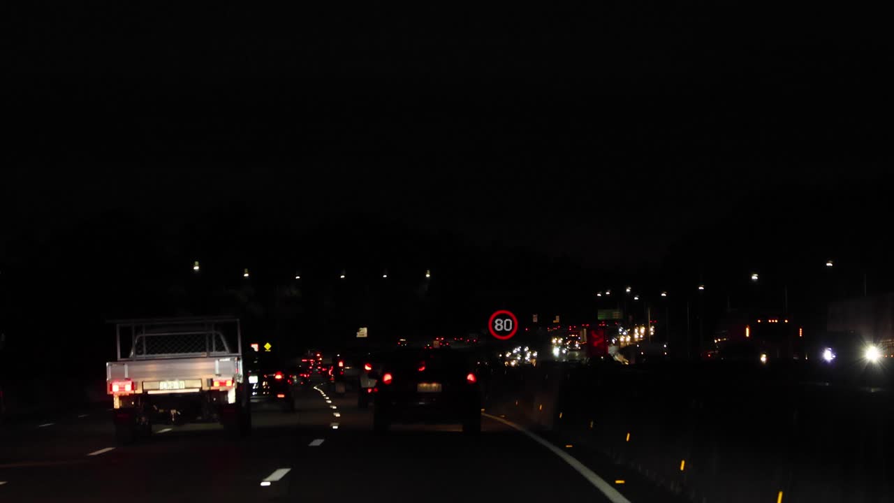 눈에 보이는 속도 제한 표지판을 가진 야간 운전 차량