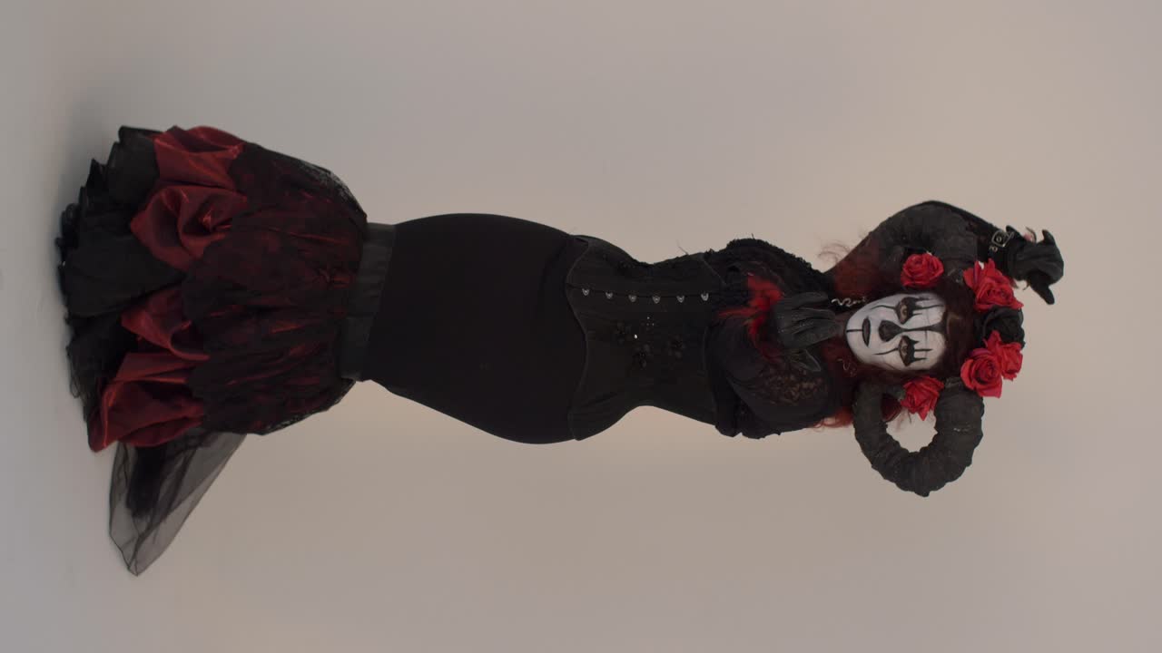 Catrina Cosplay girl moving hand slowly and steping backward in a Light background, Full shot