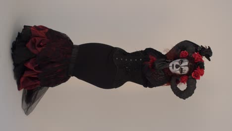 catrina cosplay girl moving hand slowly and steping backward in a light background, full shot