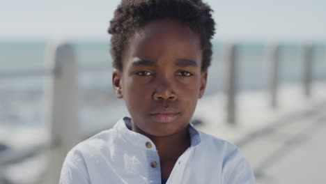 portrait angry african american boy looking unhappy arms crossed little kid tantrum on sunny seaside slow motion
