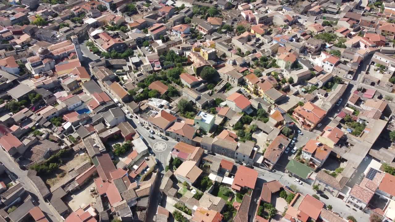 Drone view of compact Mediterranean-style neighborhood with terracotta tiled roofs, narrow streets, and greenery in sunny Valencia, Spain showing urban architecture and layout