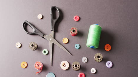 video of scissors with buttons and cotton reels on dark grey background