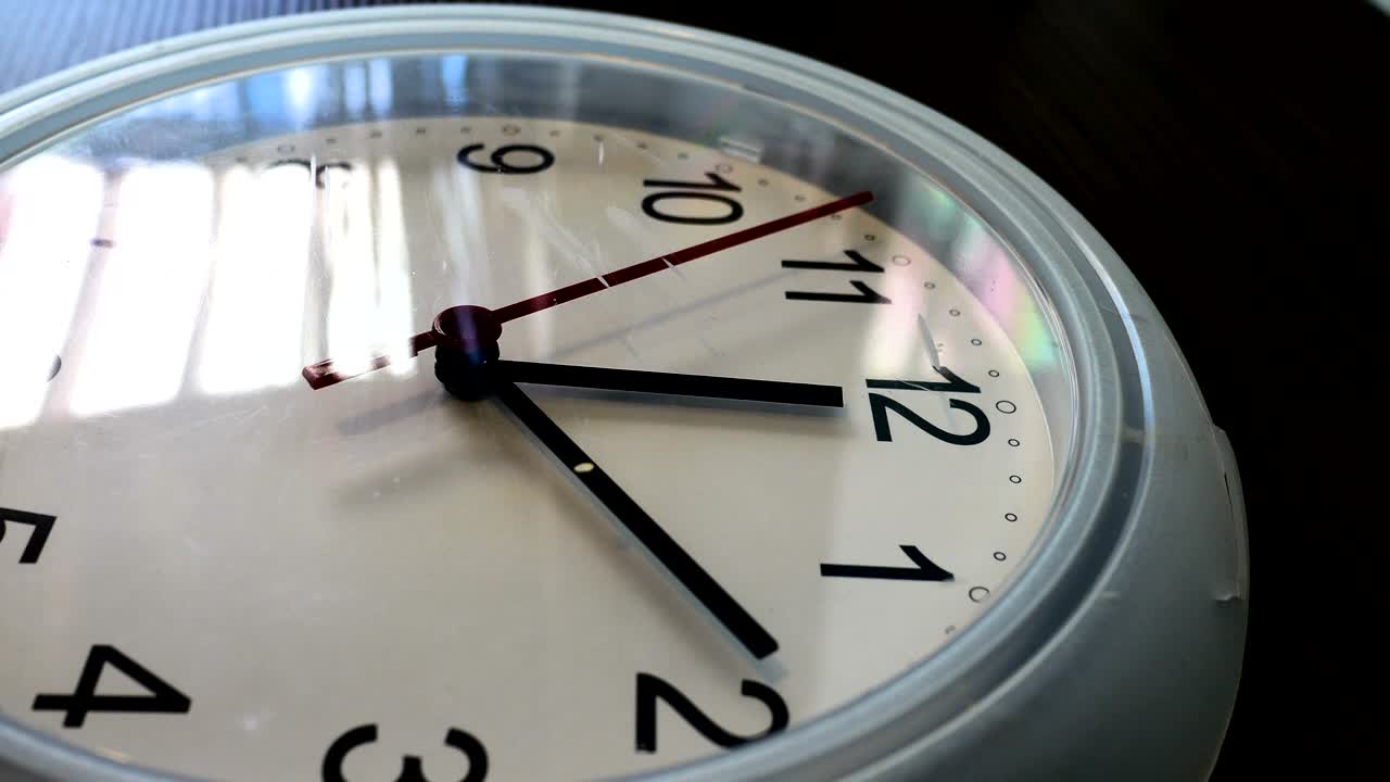 Wall clock with twelve oclock and a red ticking arrow. Professional shot in 4K resolution